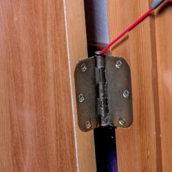 Spray oil is applied to a door hinge